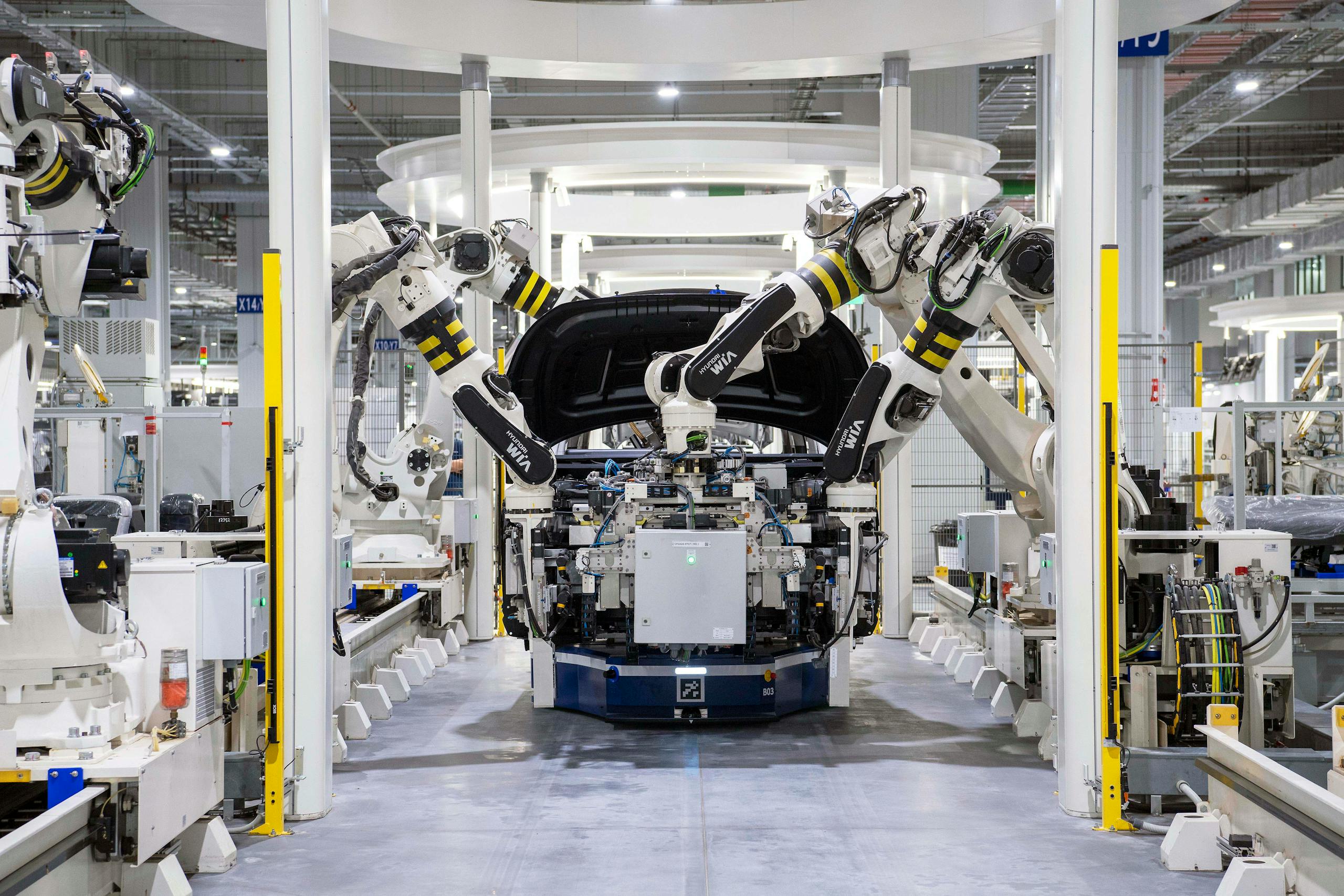 Roboty przemysłowe w hali produkcyjnej automotive