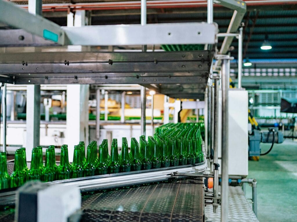 Streamlined glass bottle manufacturing process in factory setting, showcasing assembly line automation.