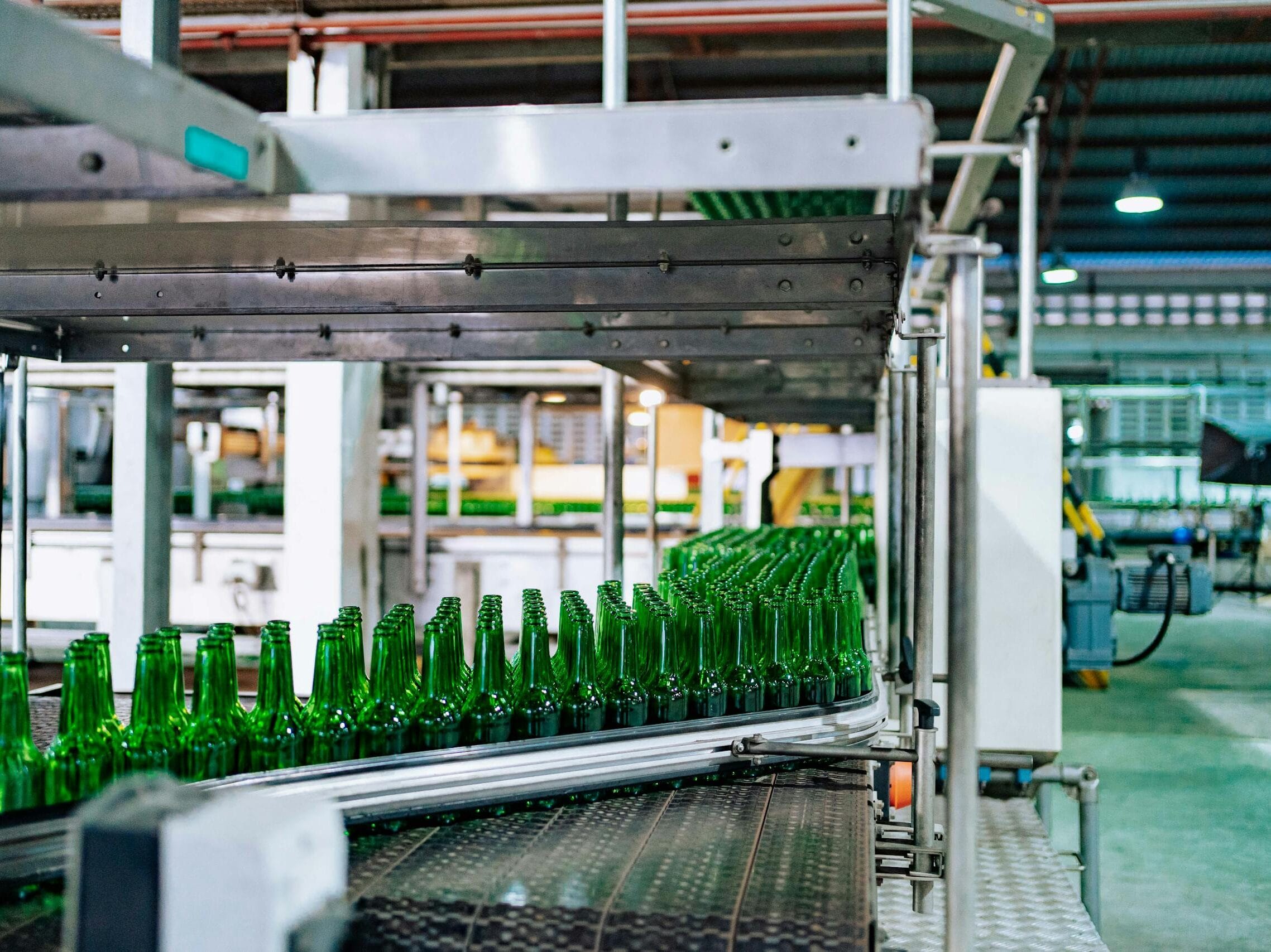 Streamlined glass bottle manufacturing process in factory setting, showcasing assembly line automation.